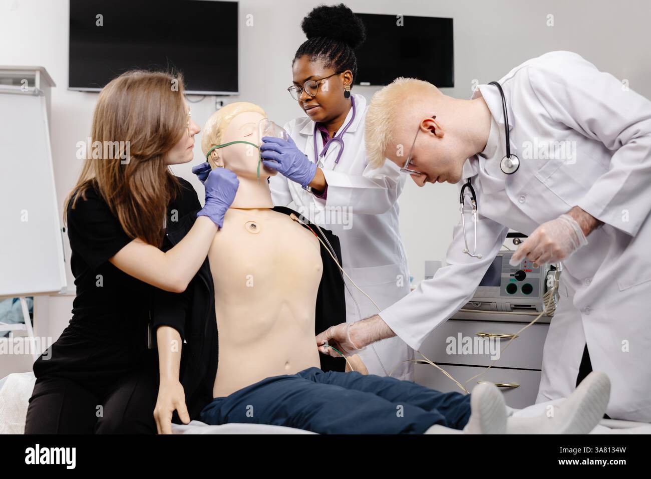 Groupe diversifié d'étudiants en médecine pratiquant l'intubation endotrachéale lors d'une formation de simulation en soins d'urgence avec un mannequin médical Banque D'Images