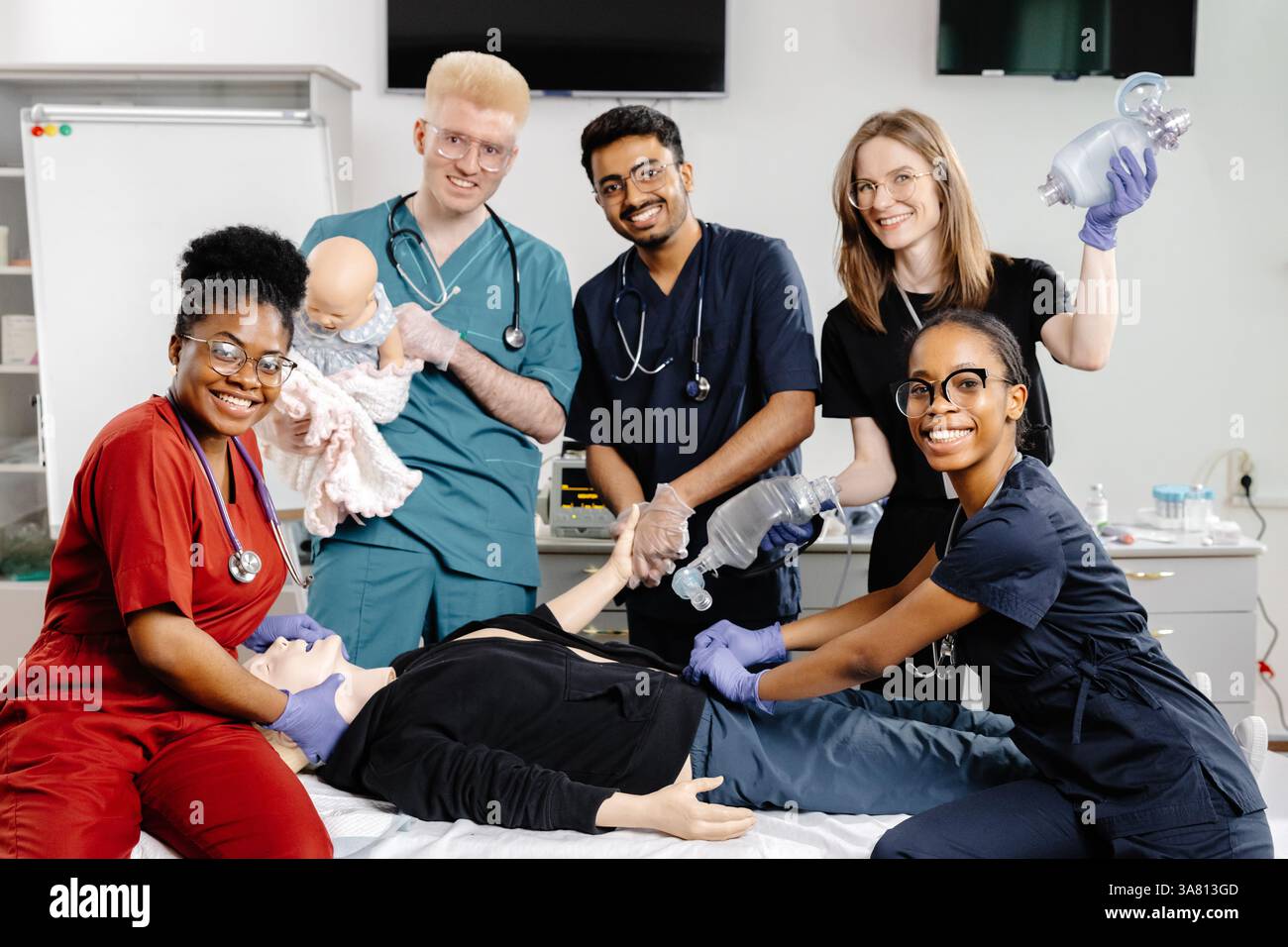 Groupe de paramédicaux apprenant à effectuer une réanimation cardiopulmonaire sur un mannequin médical lors d’une formation aux premiers soins Banque D'Images