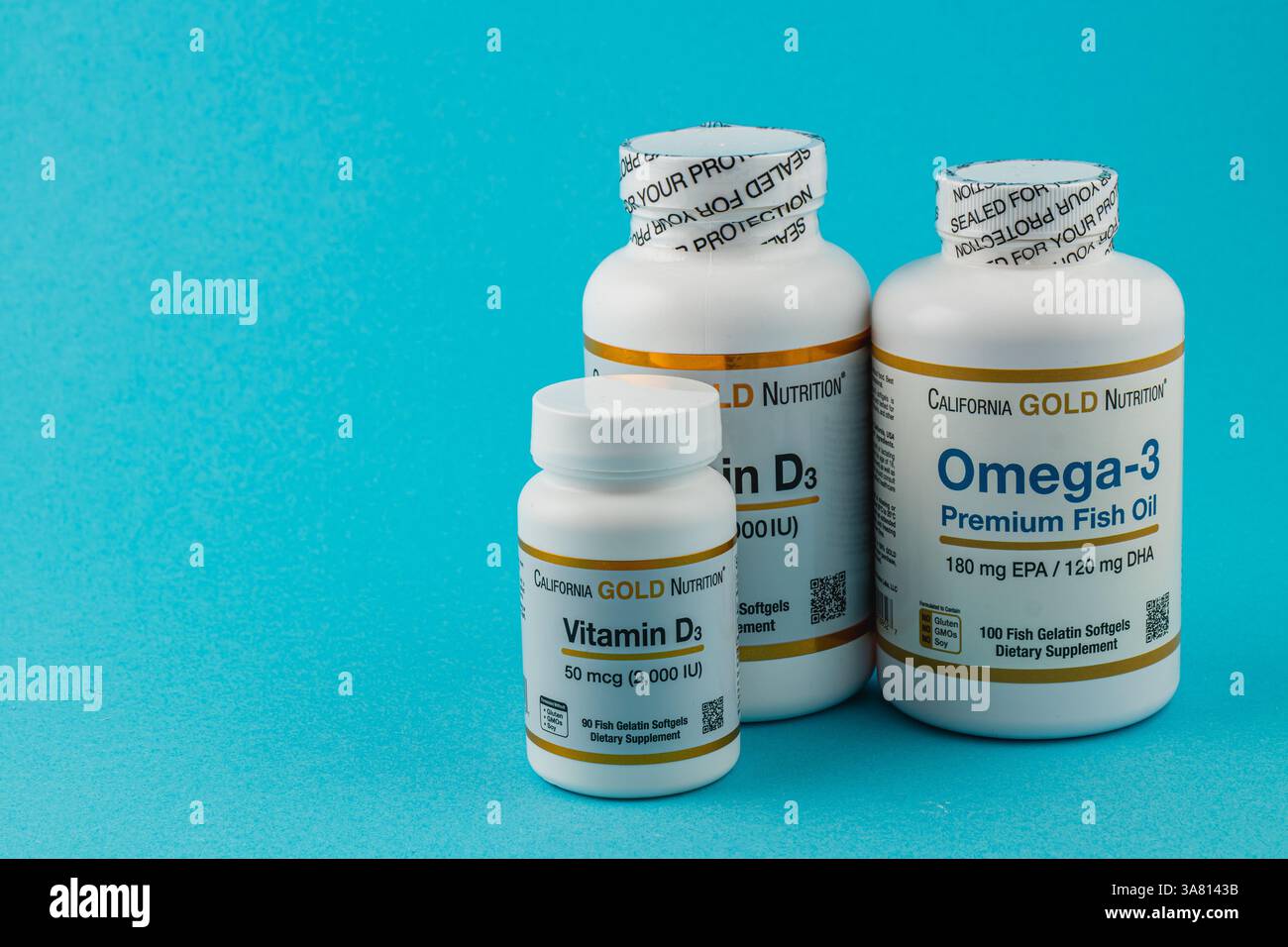 24.03.25 Lviv Ukraine trois bouteilles de compléments alimentaires sont soigneusement disposées sur un fond bleu vif. Ils comprennent la vitamine D3 et les oméga-3 F. Banque D'Images