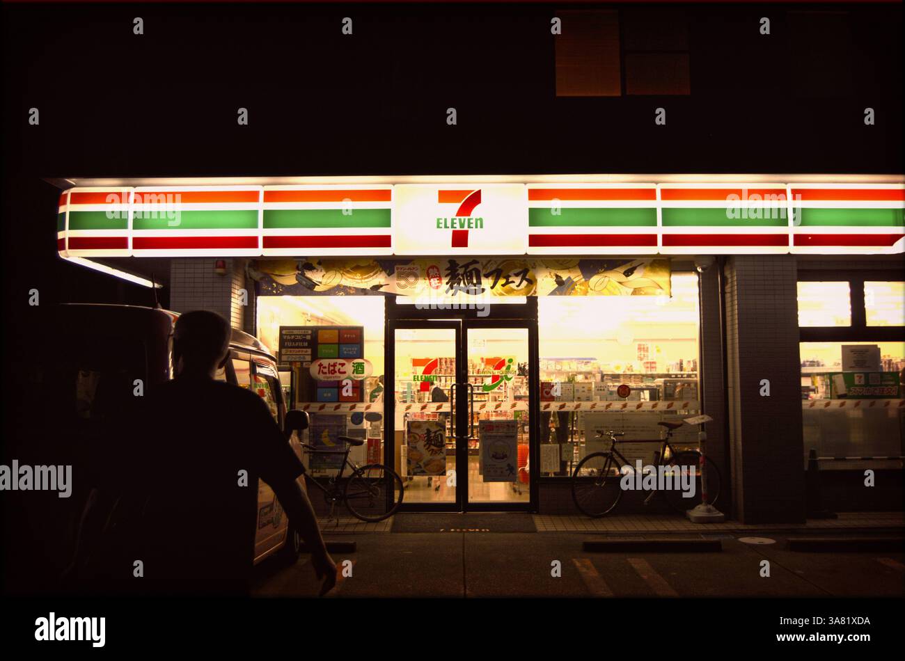 Scène nocturne au Japanese 7-Eleven : homme en approche, Silhouette Banque D'Images