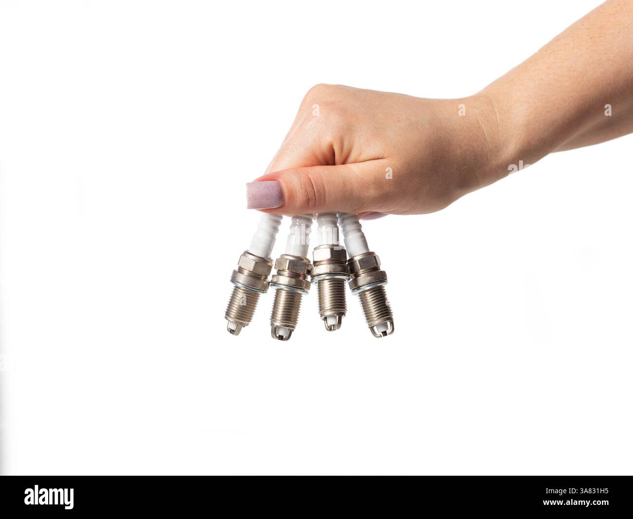 Bougies d'allumage de voiture dans la main d'une fille sur un fond blanc, isolez. Banque D'Images