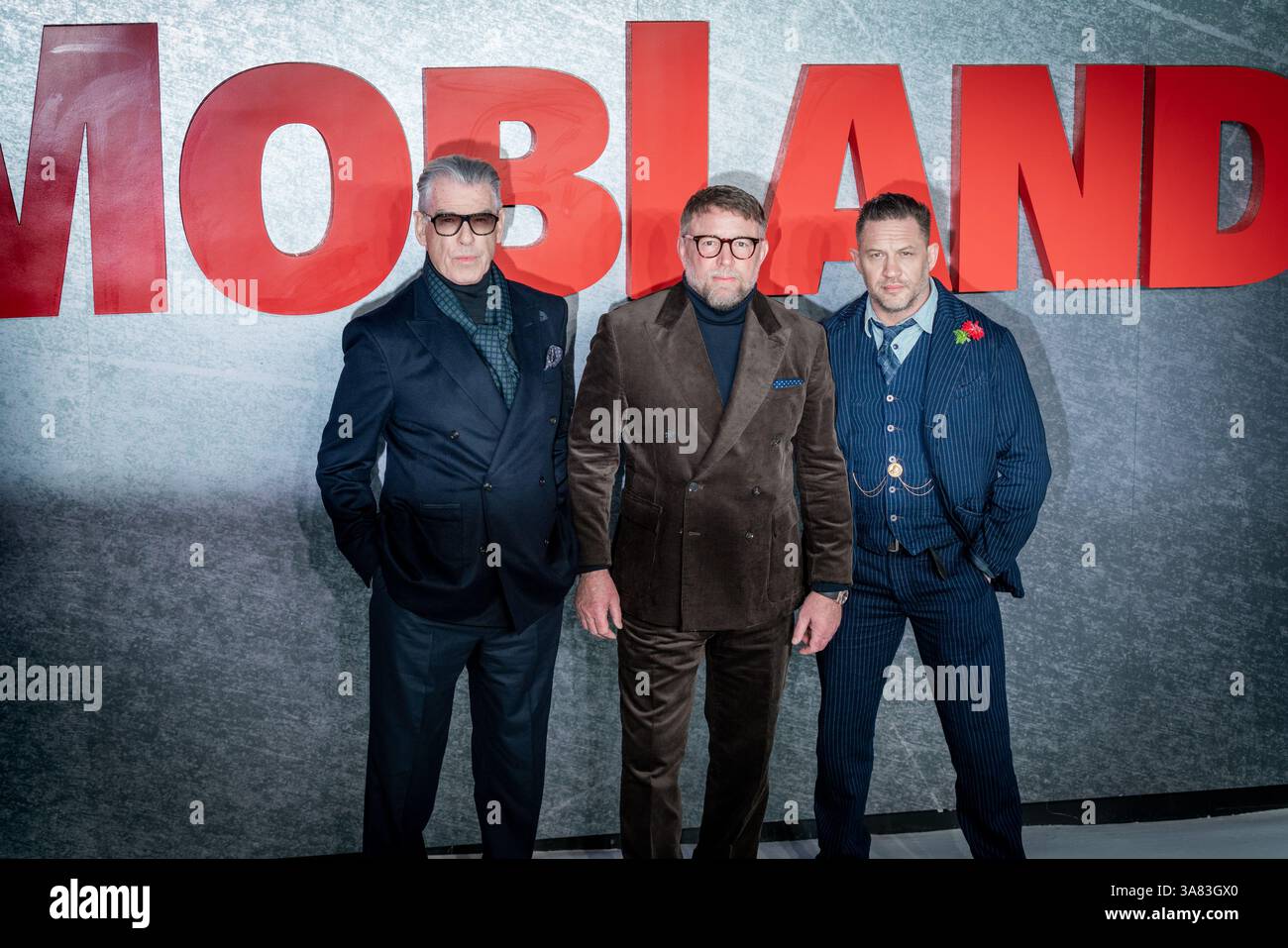 Londres, Royaume-Uni. 27 mars 2025. (G-d) Pierce Brosnan, Guy Ritchie et Tom Hardy assistent à la première mondiale de 'MobLand' à Odeon luxe Leicester Square. Crédit : Guy Corbishley/Alamy Live News Banque D'Images