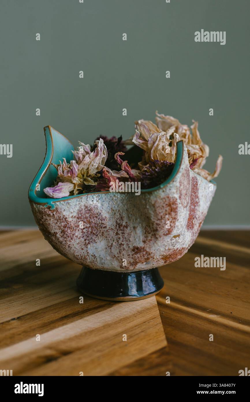 Poterie jetée à la main tenant des bourgeons de fleurs séchées Banque D'Images