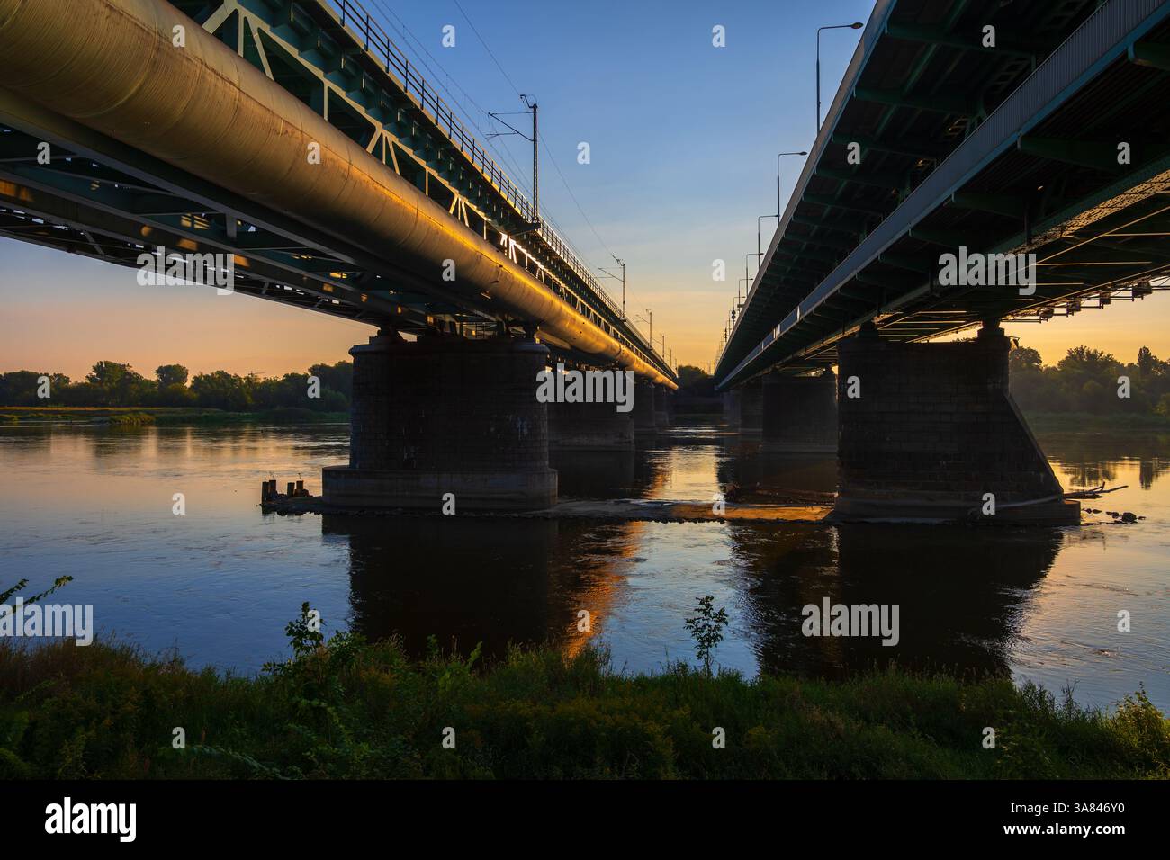 Ponts sur la Vistule au lever du soleil dans la ville de Varsovie en Pologne. Pont ferroviaire de la Citadelle (polonais : Most przy Cytadeli) et pont de Gdanski, disparaissant po Banque D'Images