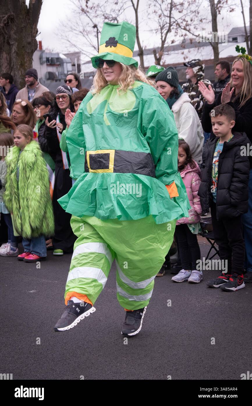 Une jolie femme dans un costume vert de la Saint Patrick danse un Irish Jig lors du défilé de 2025 à Peekskill, New York. Banque D'Images
