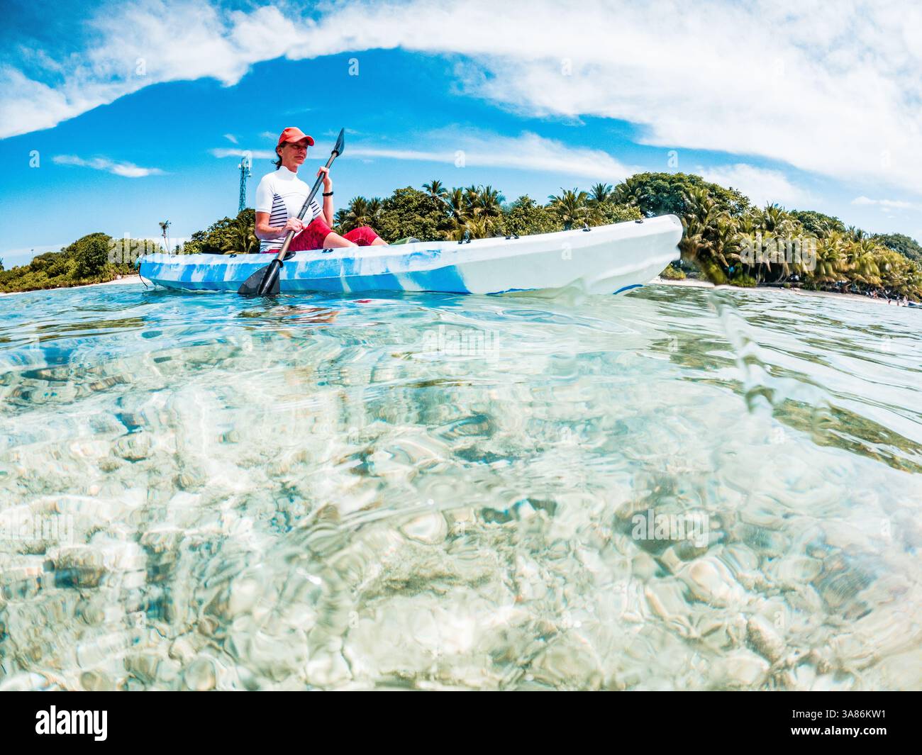 Femme kayak dans la mer tropicale claire, plaisir d'été, les Maldives, l'océan Indien Banque D'Images
