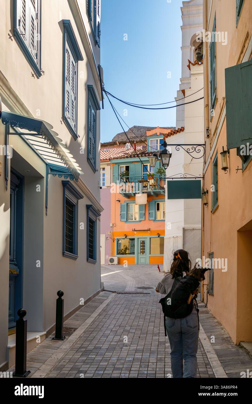 Femme avec chien dans un sac à dos marchant dans le centre-ville historique de Nauplie, Nauplie, Péloponnèse, Grèce Banque D'Images