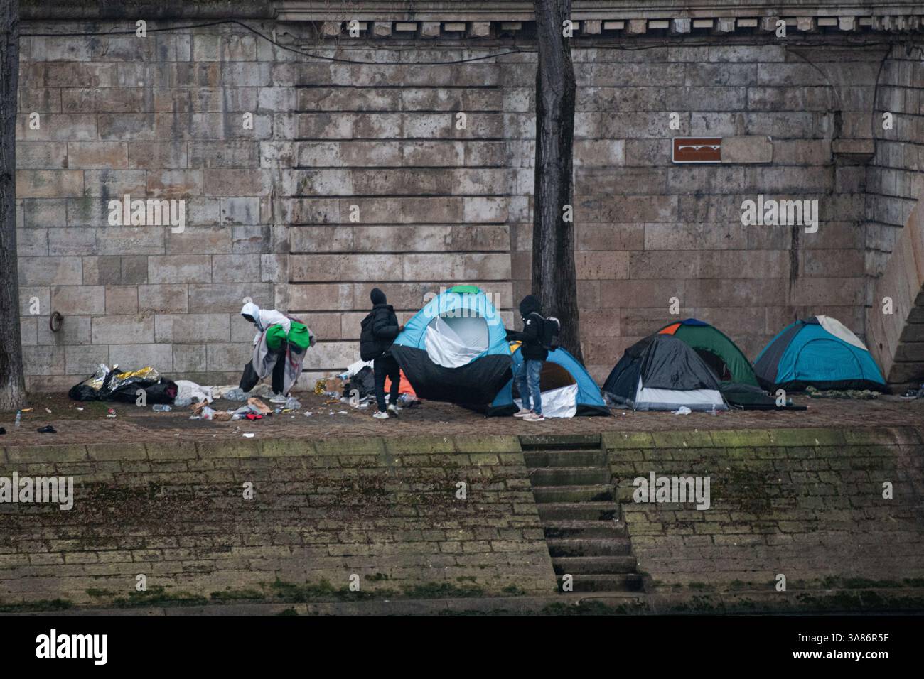 Paris, France. 28 mars 2025. Un camp de migrants de fortune a pris forme le long des rives de la Seine à Paris suite à l’expulsion des occupants du théâtre Gaîté Lyrique. Le 28 mars 2025, aux premières heures de la matinée, la préfecture de police de Paris a émis un ordre formel d'évacuation du site. L'opération est en attente d'une décision judiciaire en réponse à un appel interjeté par des organisations humanitaires. Paris, France, le 28 mars 2025. Photo Florian Poitout/ABACAPRESS. COM Credit : Abaca Press/Alamy Live News Banque D'Images