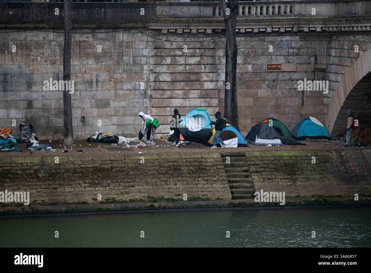 Paris, France. 28 mars 2025. Un camp de migrants de fortune a pris forme le long des rives de la Seine à Paris suite à l’expulsion des occupants du théâtre Gaîté Lyrique. Le 28 mars 2025, aux premières heures de la matinée, la préfecture de police de Paris a émis un ordre formel d'évacuation du site. L'opération est en attente d'une décision judiciaire en réponse à un appel interjeté par des organisations humanitaires. Paris, France, le 28 mars 2025. Photo Florian Poitout/ABACAPRESS. COM Credit : Abaca Press/Alamy Live News Banque D'Images
