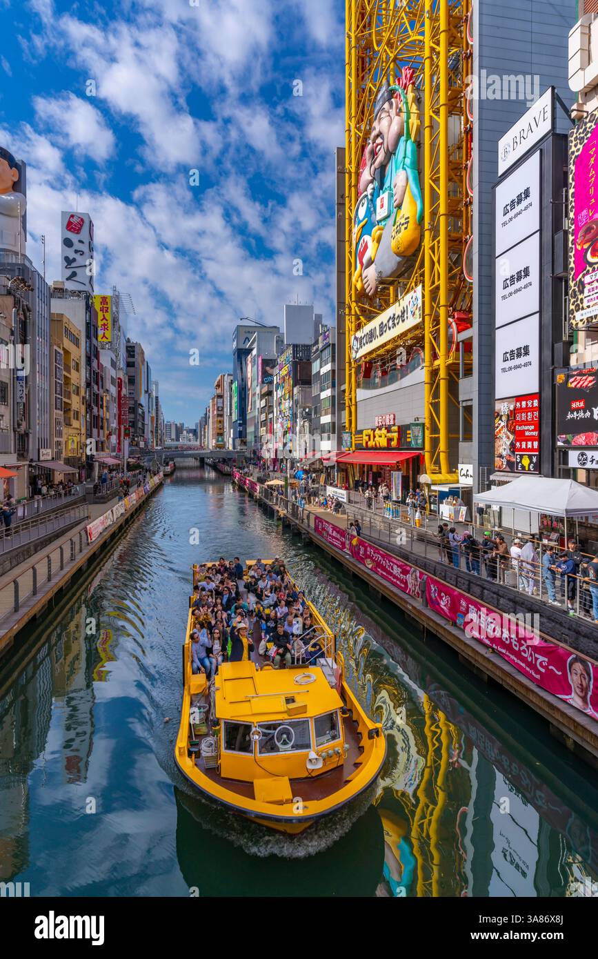 Vue sur les restaurants et le bateau d'excursion à Dotonbori, quartier animé de divertissement près de la rivière, Osaka, Honshu, Japon Banque D'Images