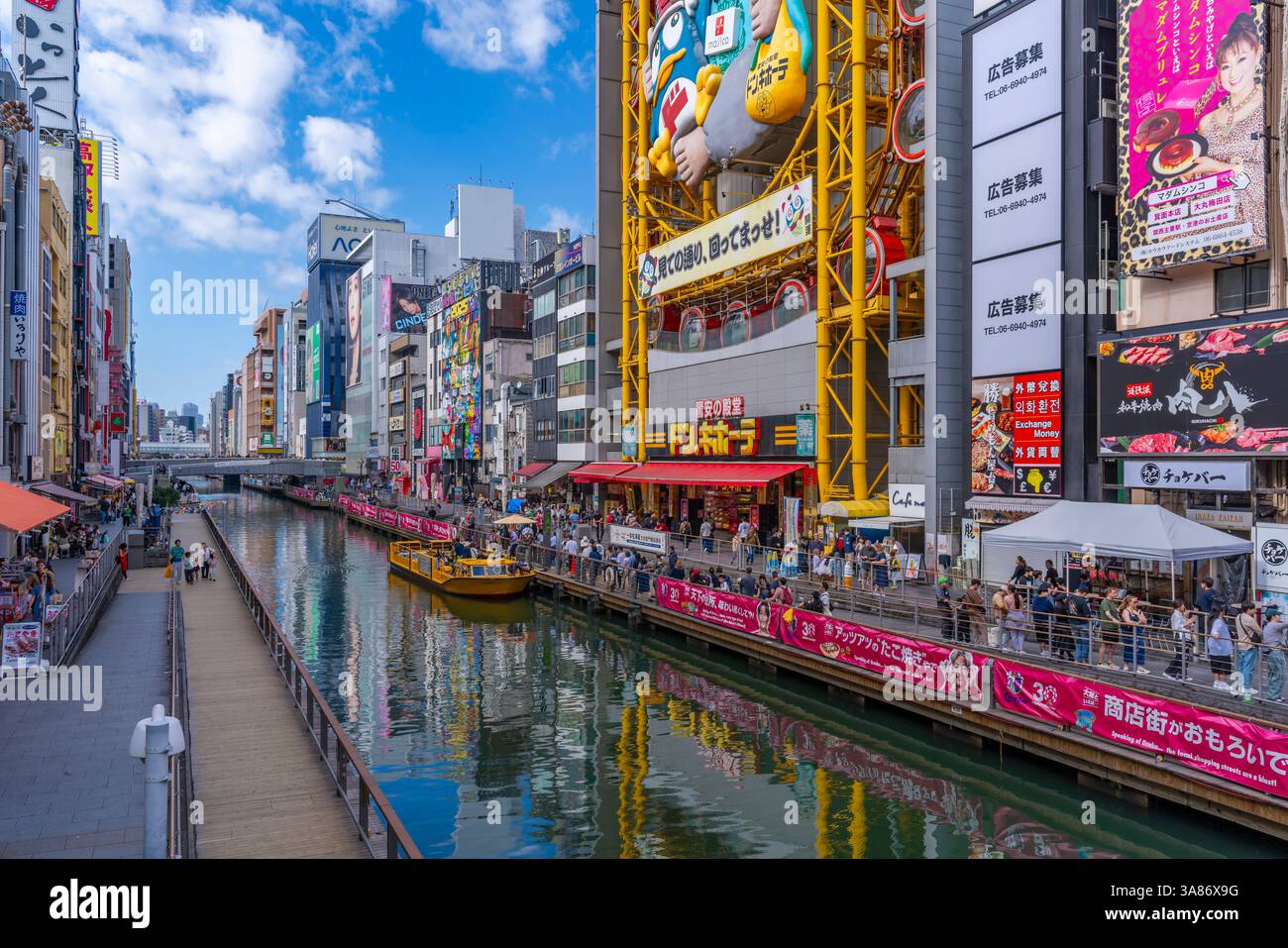 Vue sur les restaurants et le bateau d'excursion à Dotonbori, quartier animé de divertissement près de la rivière, Osaka, Honshu, Japon Banque D'Images
