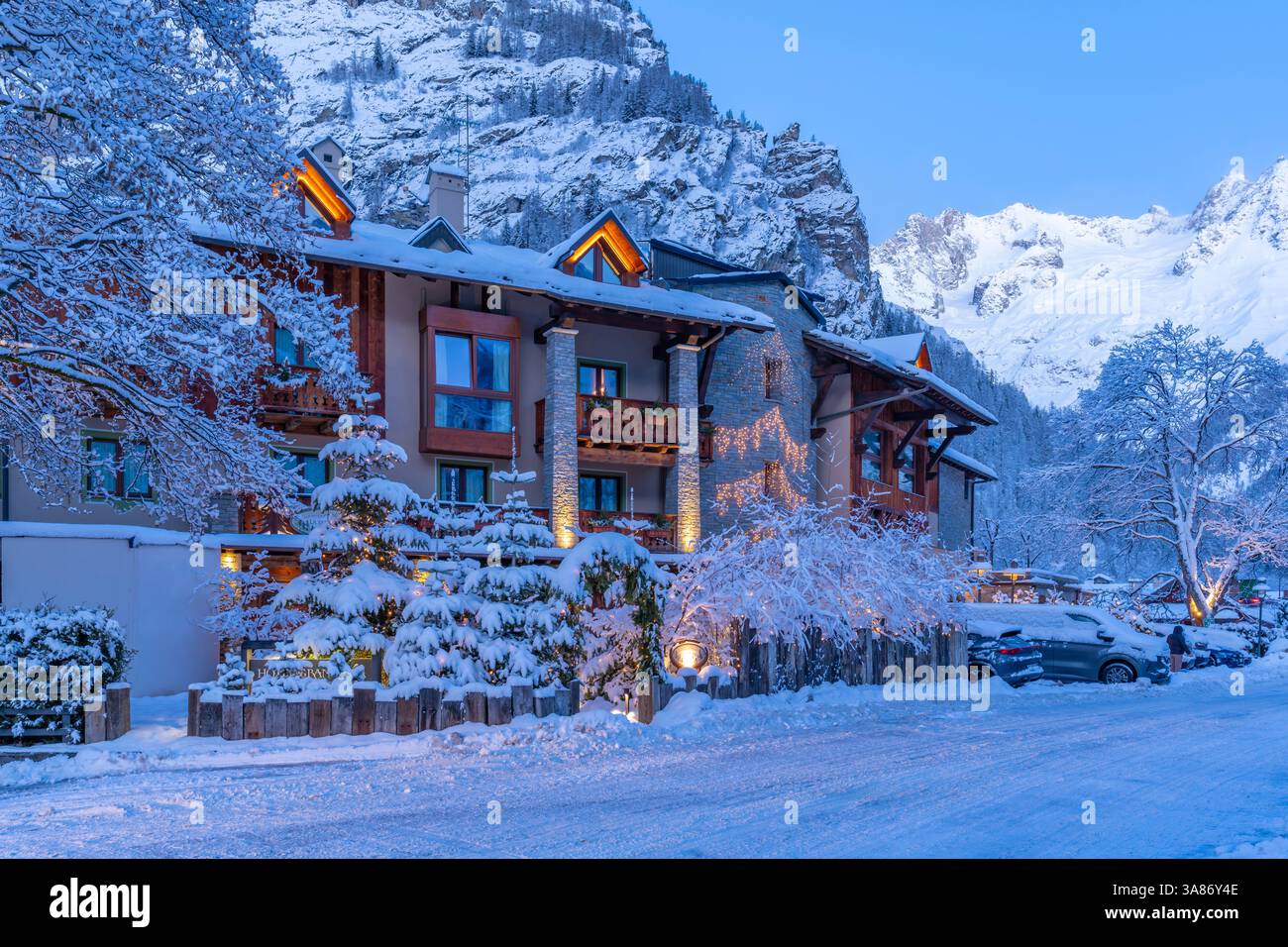 Vue sur l'hôtel et les montagnes enneigées à Courmayeur avant l'aube en hiver, Courmayeur, Vallée d'Aoste, Alpes italiennes, Italie Banque D'Images