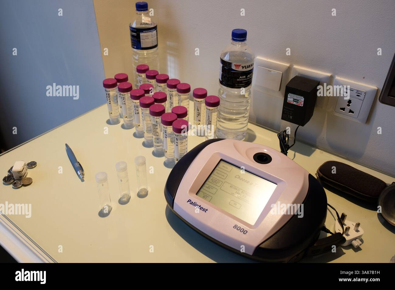 Un technicien ou un scientifique se prépare à tester plusieurs échantillons d'eau pour détecter l'azote nitré à l'aide d'un photomètre Palintest 8000 afin de déterminer la qualité de l'eau. Banque D'Images