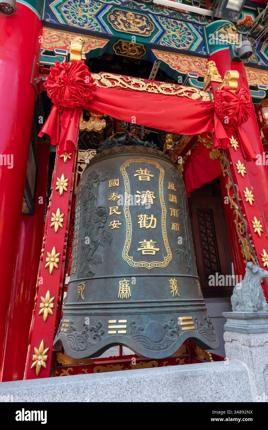 Hong Kong. Chine- 02.24.2025. La grande cloche en bronze, ornée de caractères chinois, située sur le côté de Sik Sik Yuen Wong Tai Sin Temple bui Banque D'Images