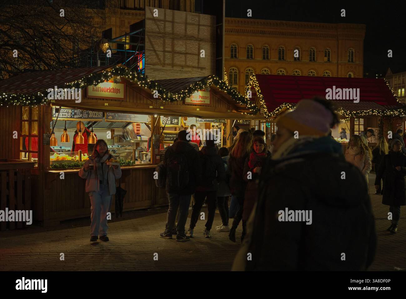 Les gens sont rassemblés au marché de Noël pour acheter de la nourriture et des collations dans les étals, Alexanderplatz Berlin Banque D'Images