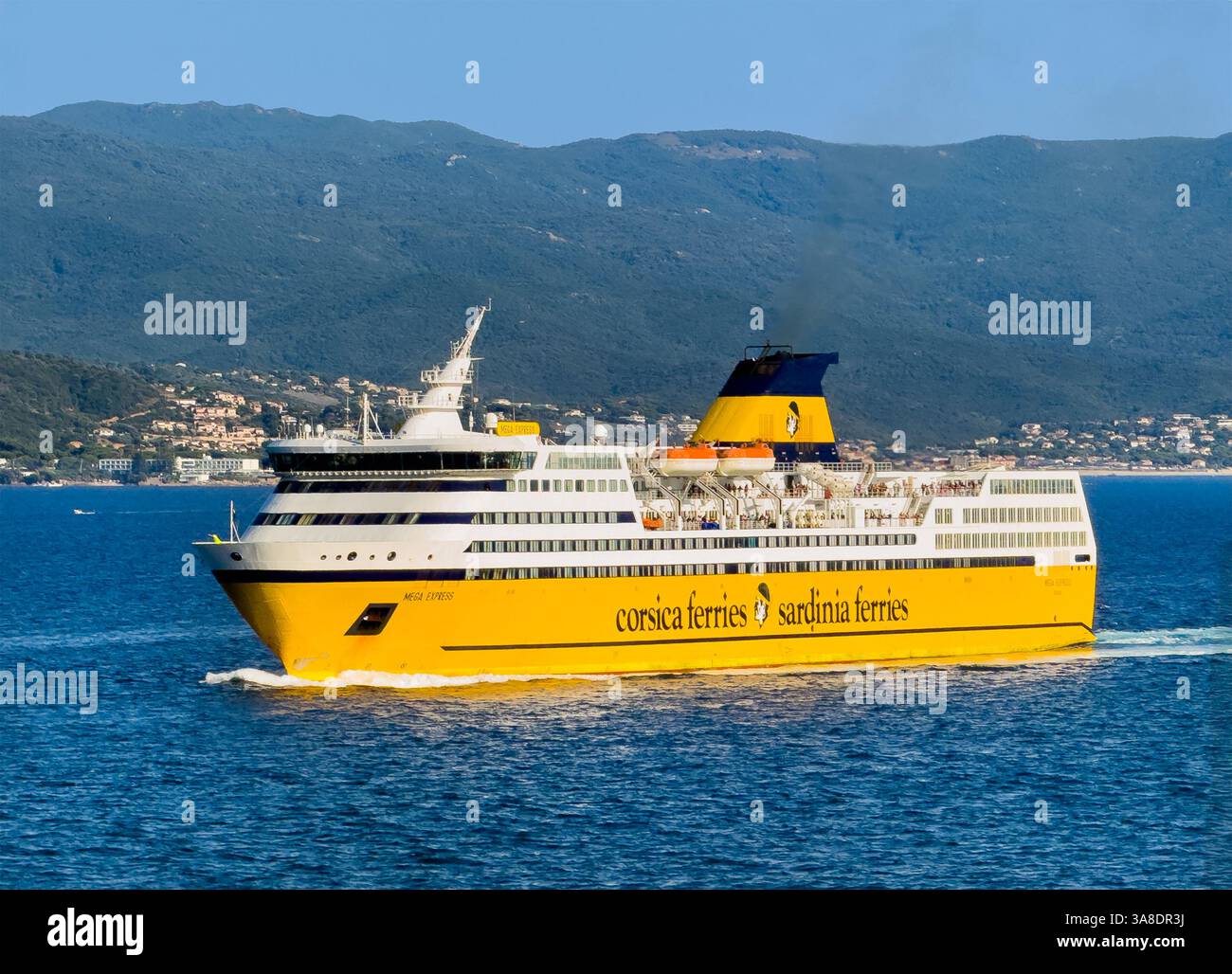 Ajaccio, Corse, France 8 juillet 2024 : Corsica Ferries et Sardinia Ferries, le même navire, entrent dans le port. Côte avec montagnes boisées et bâtiments a Banque D'Images