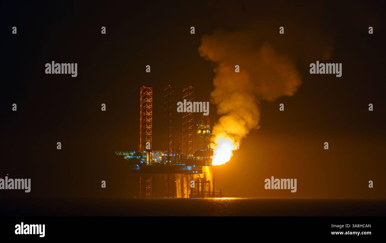 Doha, Qatar - 14 janvier 2024, vue panoramique de la plate-forme pétrolière, qui brûle l'excès de gaz naturel, pendant la production de pétrole, dans le golfe Persique, la nuit, Doha, Banque D'Images