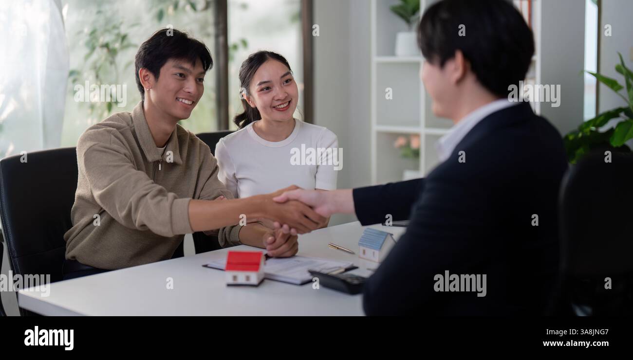Négociation et conclusion réussies. Un couple et leur agent immobilier finalisent le processus d’achat de la maison. Banque D'Images