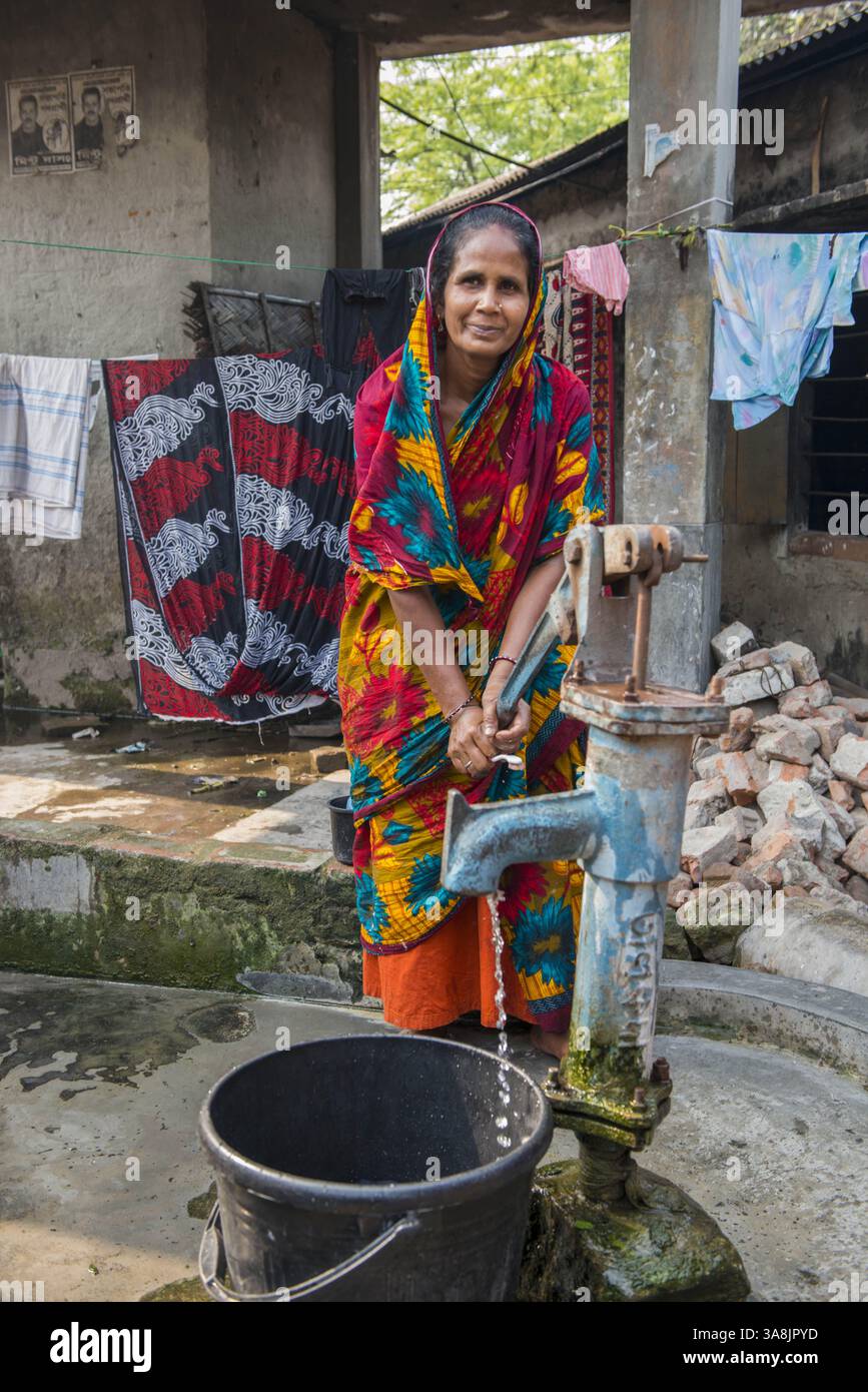 28 janvier 2012 - Khulna, Khulna, Bangladesh - Bangladesh, Khulna, colonie de balayeuses Sonadanga. La plupart de ces personnes qui vivent dans ce bidonville sont des Dalits hindous, ou la caste intouchable travaillant comme balayeuses et nettoyeuses de toilettes. Il y a environ 5,5 millions de Dalits à travers le pays, ce sont les castes les plus négligées dans leur société. Femme pompant de l'eau. (Crédit image : © Alison Wright via ZUMA Wire) Banque D'Images