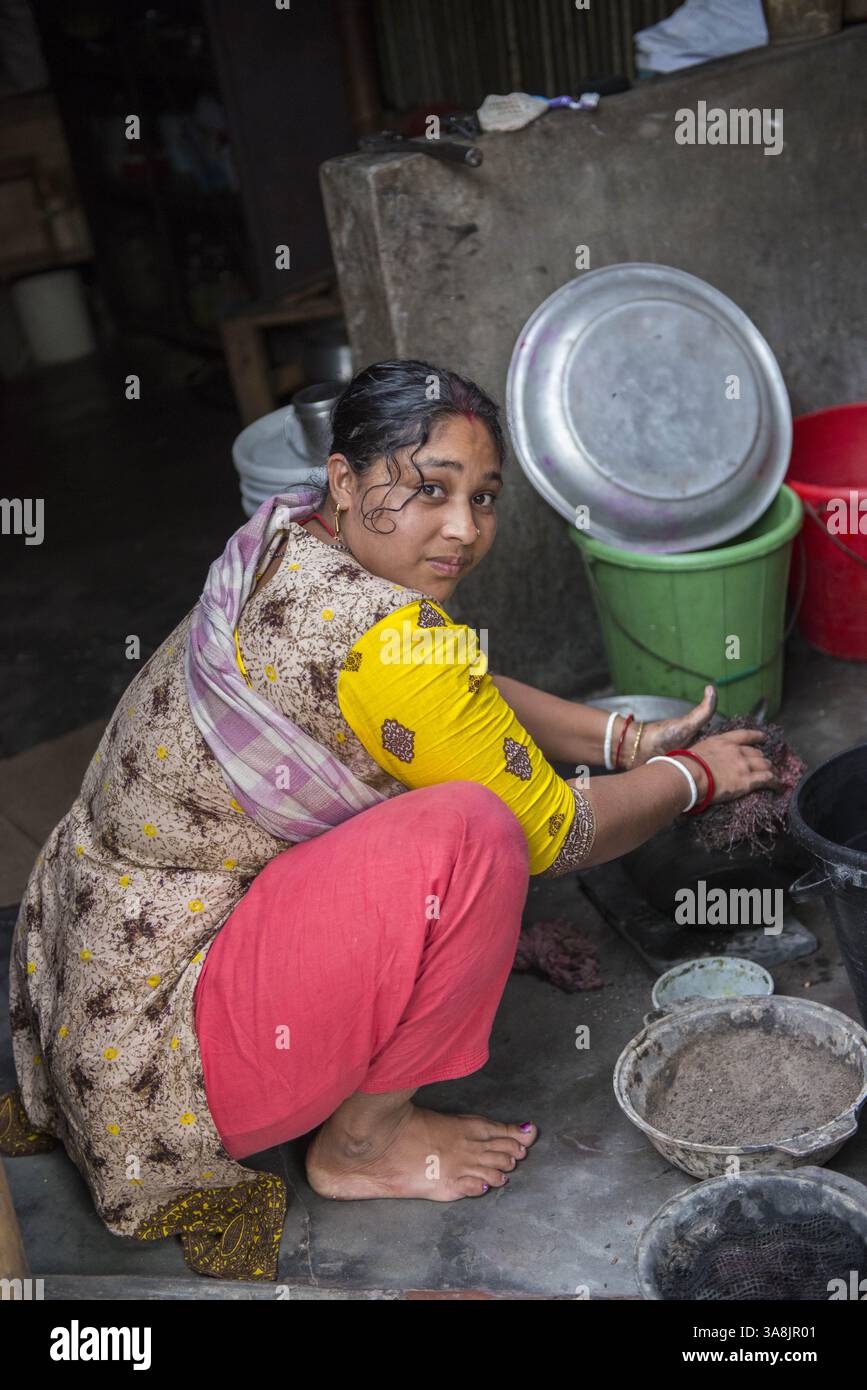 28 janvier 2012 - Khulna, Khulna, Bangladesh - Bangladesh, Khulna, colonie de balayeuses Sonadanga. La plupart de ces personnes qui vivent dans ce bidonville sont des Dalits hindous, ou la caste intouchable travaillant comme balayeuses et nettoyeuses de toilettes. Il y a environ 5,5 millions de Dalits à travers le pays, ce sont les castes les plus négligées dans leur société. Femme à la maison nettoyant des pots. (Crédit image : © Alison Wright via ZUMA Wire) Banque D'Images
