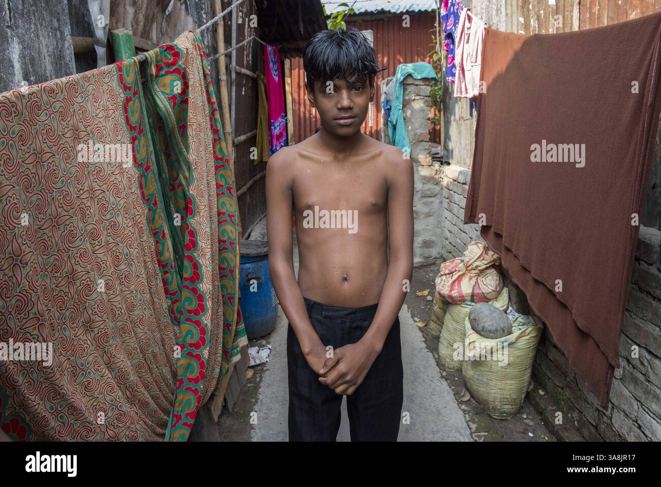 29 janvier 2012 - Khulna, Khulna, Bangladesh - Bangladesh, Khulna, colonie de balayeuses Sonadanga. La plupart de ces personnes qui vivent dans ce bidonville sont des Dalits hindous, ou la caste intouchable travaillant comme balayeuses et nettoyeuses de toilettes. Il y a environ 5,5 millions de Dalits à travers le pays, ce sont les castes les plus négligées dans la société. Garçon debout dans la rue. (Crédit image : © Alison Wright via ZUMA Wire) Banque D'Images