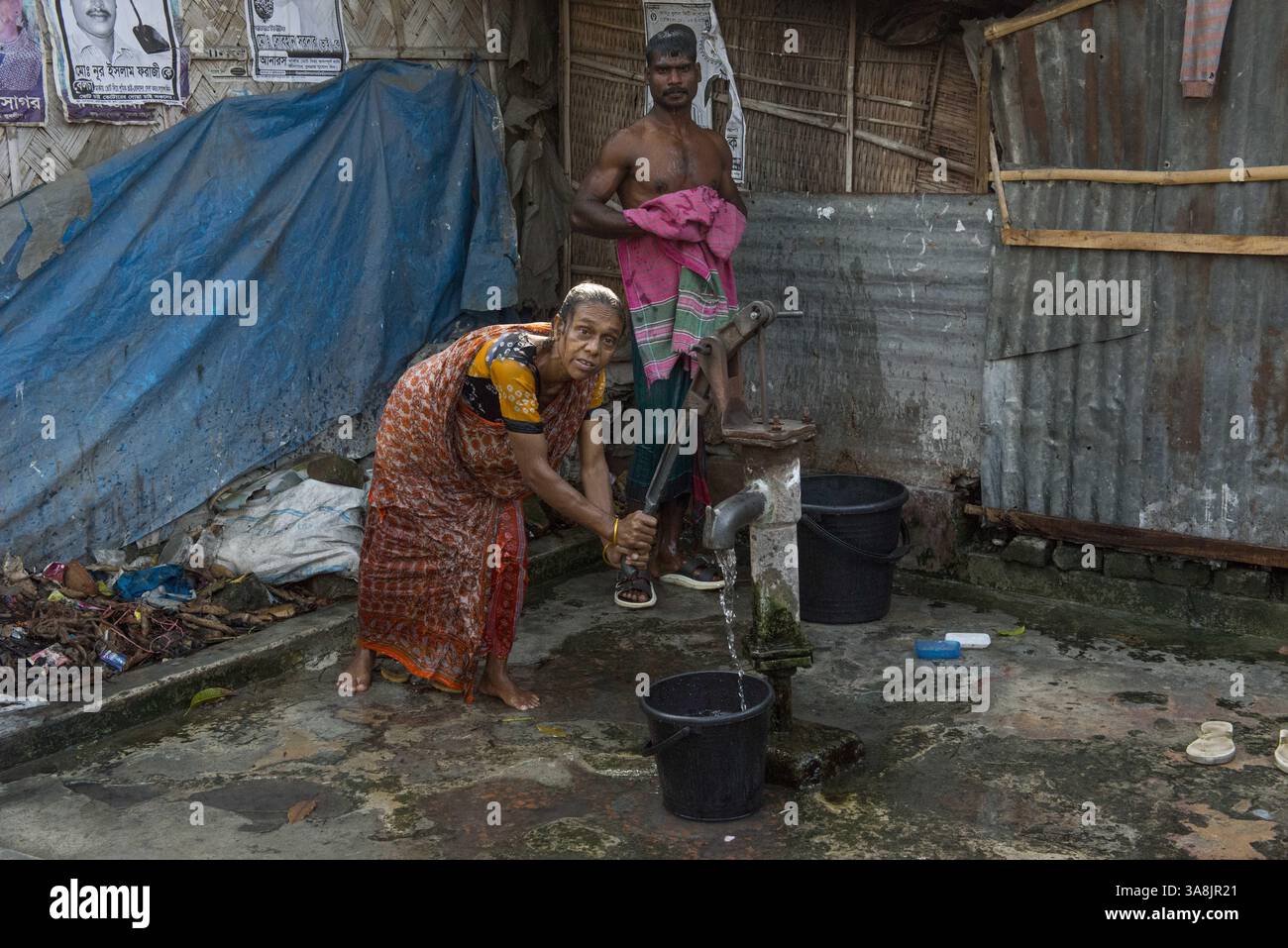 29 janvier 2012 - Khulna, Khulna, Bangladesh - Bangladesh, Khulna, colonie de balayeuses Sonadanga. La plupart de ces personnes qui vivent dans ce bidonville sont des Dalits hindous, ou la caste intouchable travaillant comme balayeuses et nettoyeuses de toilettes. Il y a environ 5,5 millions de Dalits à travers le pays, ce sont les castes les plus négligées dans la société. Femmes pompant de l'eau au puits. (Crédit image : © Alison Wright via ZUMA Wire) Banque D'Images