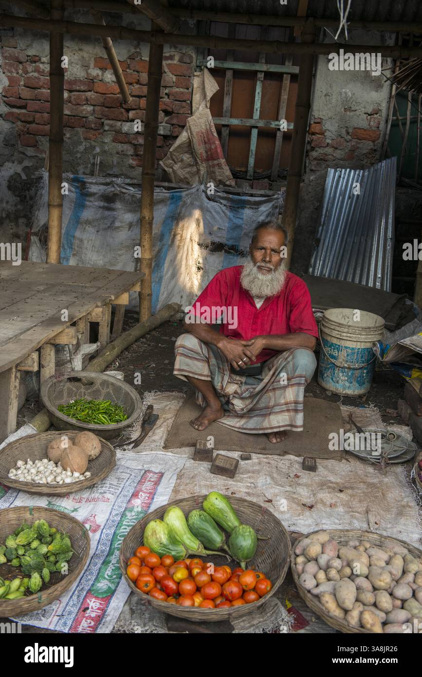 29 janvier 2012 - Khulna, Khulna, Bangladesh - Bangladesh, Khulna, colonie de balayeuses Sonadanga. La plupart de ces personnes qui vivent dans ce bidonville sont des Dalits hindous, ou la caste intouchable travaillant comme balayeuses et nettoyeuses de toilettes. Il y a environ 5,5 millions de Dalits à travers le pays, ce sont les castes les plus négligées dans la société. Homme à la barbe vendant des légumes au marché. (Crédit image : © Alison Wright via ZUMA Wire) Banque D'Images