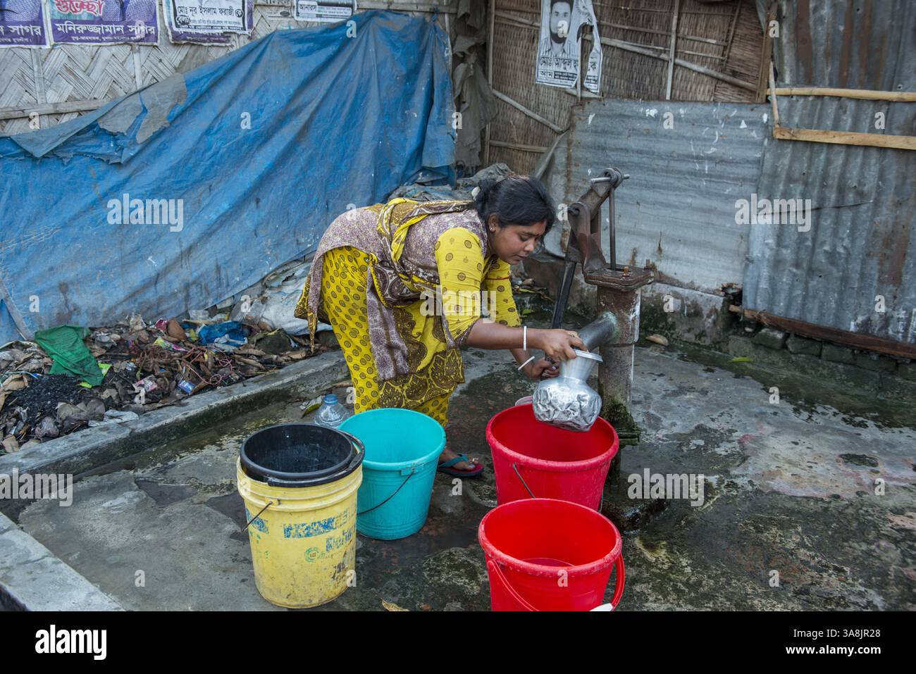 29 janvier 2012 - Khulna, Khulna, Bangladesh - Bangladesh, Khulna, colonie de balayeuses Sonadanga. La plupart de ces personnes qui vivent dans ce bidonville sont des Dalits hindous, ou la caste intouchable travaillant comme balayeuses et nettoyeuses de toilettes. Il y a environ 5,5 millions de Dalits à travers le pays, ce sont les castes les plus négligées dans la société. Femmes pompant de l'eau au puits. (Crédit image : © Alison Wright via ZUMA Wire) Banque D'Images