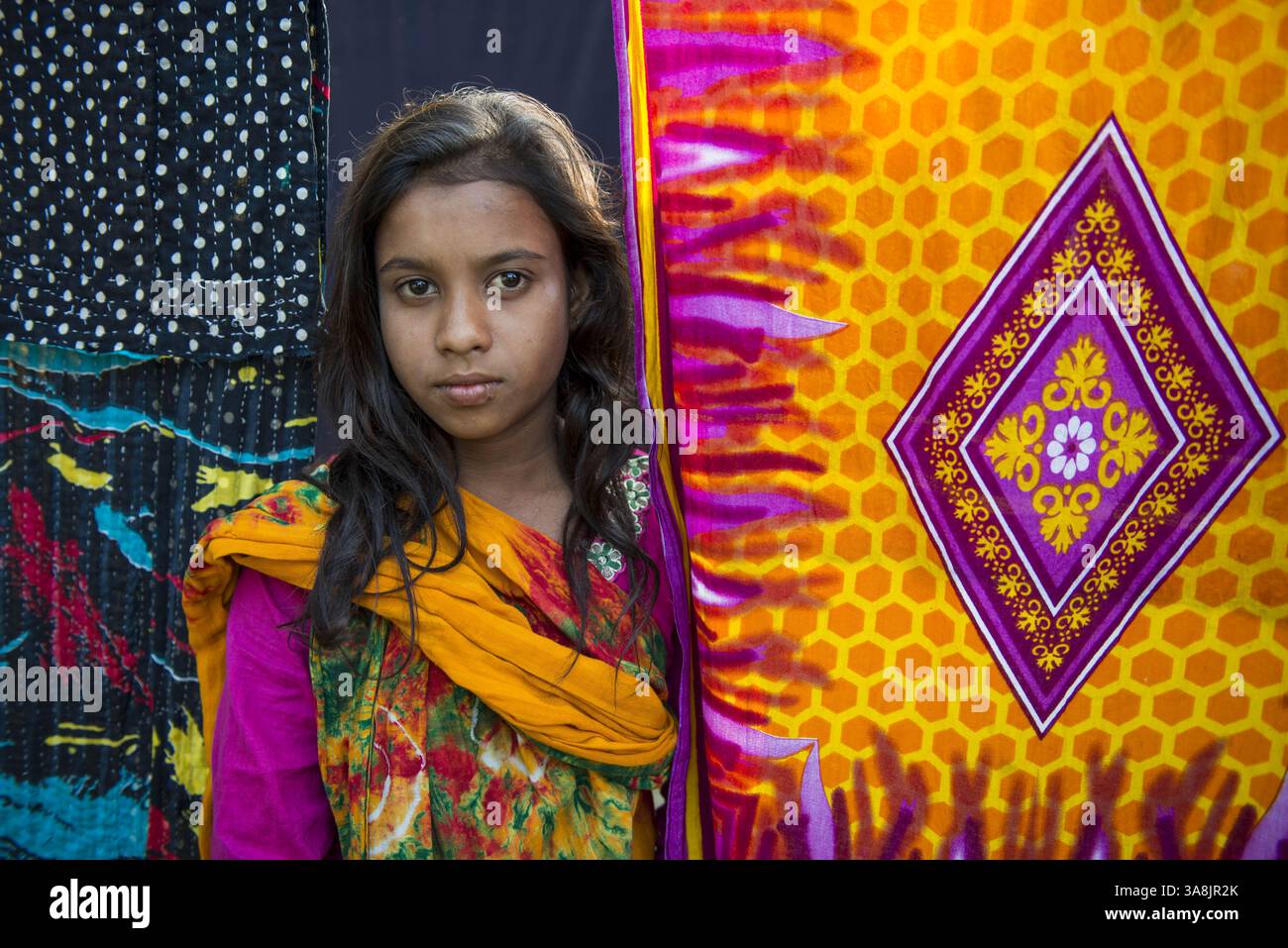 29 janvier 2012 - Khulna, Khulna, Bangladesh - Bangladesh, Khulna, colonie de balayeuses Sonadanga. La plupart de ces personnes qui vivent dans ce bidonville sont des Dalits hindous, ou la caste intouchable travaillant comme balayeuses et nettoyeuses de toilettes. Il y a environ 5,5 millions de Dalits à travers le pays, ce sont les castes les plus négligées dans la société. Fille devant le sari séchant. (Crédit image : © Alison Wright via ZUMA Wire) Banque D'Images