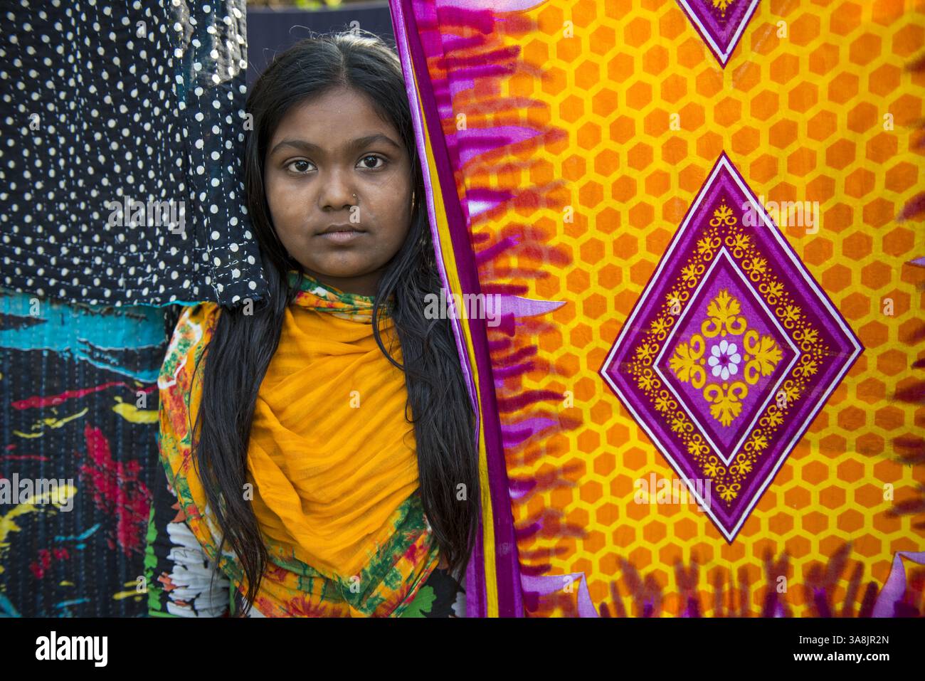 29 janvier 2012 - Khulna, Khulna, Bangladesh - Bangladesh, Khulna, colonie de balayeuses Sonadanga. La plupart de ces personnes qui vivent dans ce bidonville sont des Dalits hindous, ou la caste intouchable travaillant comme balayeuses et nettoyeuses de toilettes. Il y a environ 5,5 millions de Dalits à travers le pays, ce sont les castes les plus négligées dans la société. Fille devant le sari séchant. (Crédit image : © Alison Wright via ZUMA Wire) Banque D'Images