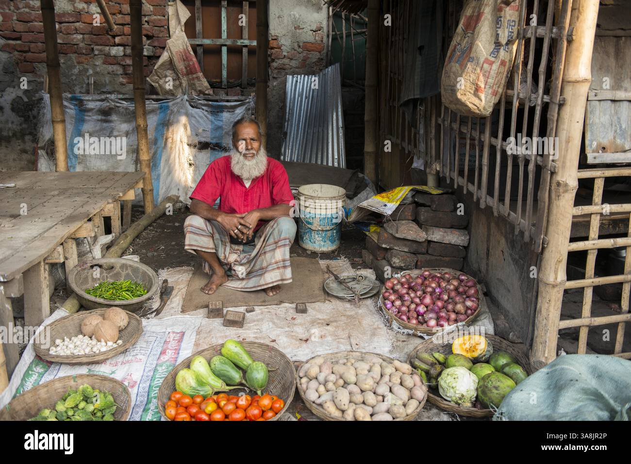 29 janvier 2012 - Khulna, Khulna, Bangladesh - Bangladesh, Khulna, colonie de balayeuses Sonadanga. La plupart de ces personnes qui vivent dans ce bidonville sont des Dalits hindous, ou la caste intouchable travaillant comme balayeuses et nettoyeuses de toilettes. Il y a environ 5,5 millions de Dalits à travers le pays, ce sont les castes les plus négligées dans la société. Homme à la barbe vendant des légumes au marché. (Crédit image : © Alison Wright via ZUMA Wire) Banque D'Images