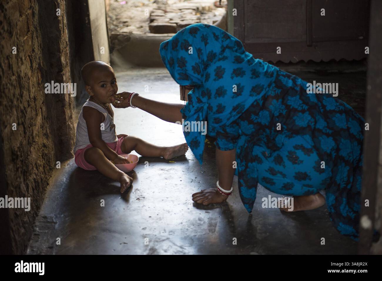29 janvier 2012 - Khulna, Khulna, Bangladesh - Bangladesh, Khulna, colonie de balayeuses Sonadanga. La plupart de ces personnes qui vivent dans ce bidonville sont des Dalits hindous, ou la caste intouchable travaillant comme balayeuses et nettoyeuses de toilettes. Il y a environ 5,5 millions de Dalits à travers le pays, ce sont les castes les plus négligées dans la société. Femme nourrissant son bébé à la maison. (Crédit image : © Alison Wright via ZUMA Wire) Banque D'Images