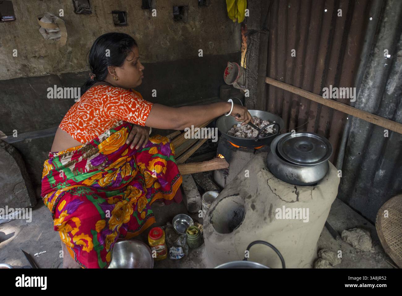 31 janvier 2012 - Jhenaidah, Jhenaidah, Bangladesh - Bangladesh, Jhenaidah. Colonie de balayeuse Chaklapara. La plupart de ces personnes qui vivent dans ce bidonville sont des Dalits hindous, ou la caste intouchable travaillant comme balayeuses et nettoyeuses de toilettes. Il y a environ 5,5 millions de Dalits à travers le pays, ce sont les castes les plus négligées dans leur société. Femme cuisinant au four en argile. (Crédit image : © Alison Wright via ZUMA Wire) Banque D'Images