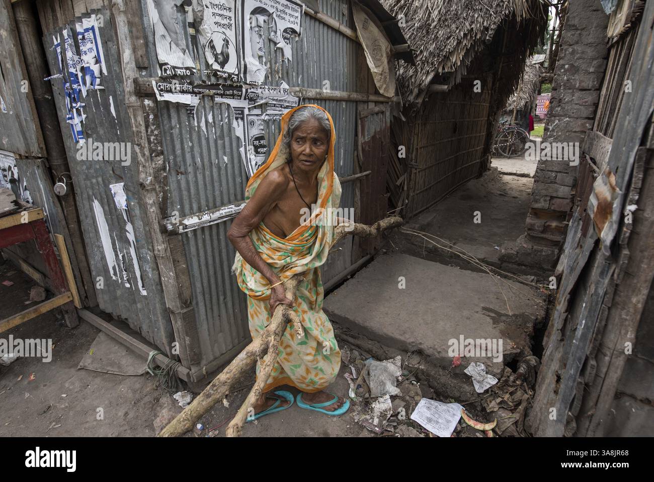 18 mars 2017 - Khulna, Khulna, Bangladesh - Bangladesh, Khulna, colonie de balayeuses Sonadanga. La plupart de ces personnes qui vivent dans ce bidonville sont des Dalits hindous, ou la caste intouchable travaillant comme balayeuses et nettoyeuses de toilettes. Il y a environ 5,5 millions de Dalits dans tout le pays, ce sont les castes les plus négligées de la société. Femme transportant des bûches à travers le bidonville. (Crédit image : © Alison Wright via ZUMA Wire) Banque D'Images