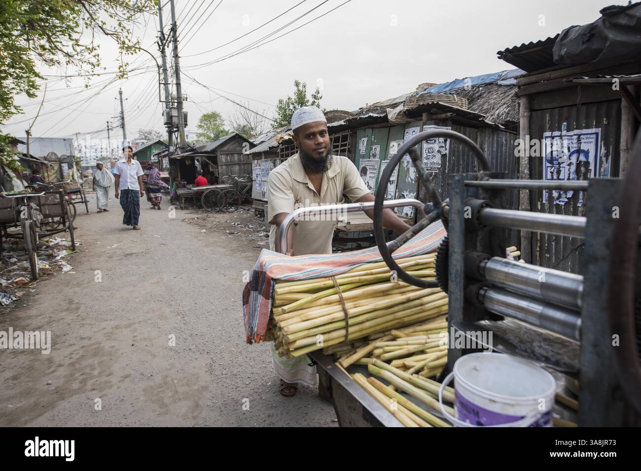 18 mars 2017 - Khulna, Khulna, Bangladesh - Bangladesh, Khulna, colonie de balayeuses Sonadanga. La plupart de ces personnes qui vivent dans ce bidonville sont des Dalits hindous, ou la caste intouchable travaillant comme balayeuses et nettoyeuses de toilettes. Il y a environ 5,5 millions de Dalits dans tout le pays, ce sont les castes les plus négligées de la société. Homme avec machine à jus de canne à sucre. (Crédit image : © Alison Wright via ZUMA Wire) Banque D'Images