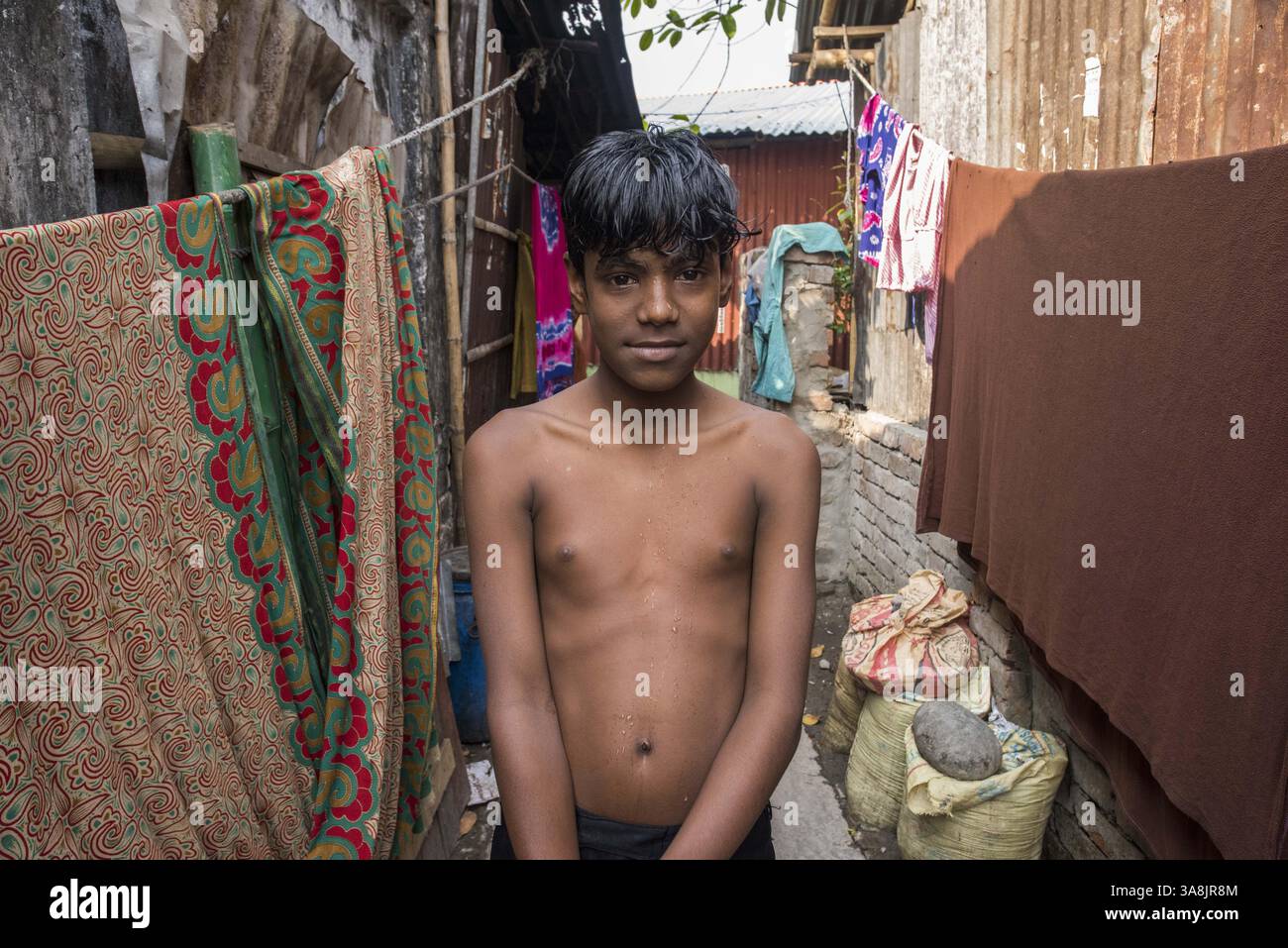 19 mars 2017 - Khulna, Khulna, Bangladesh - Bangladesh, Khulna, colonie de balayeuses Sonadanga. La plupart de ces personnes qui vivent dans ce bidonville sont des Dalits hindous, ou la caste intouchable travaillant comme balayeuses et nettoyeuses de toilettes. Il y a environ 5,5 millions de Dalits à travers le pays, ce sont les castes les plus négligées dans la société. Garçon debout dans la rue. (Crédit image : © Alison Wright via ZUMA Wire) Banque D'Images