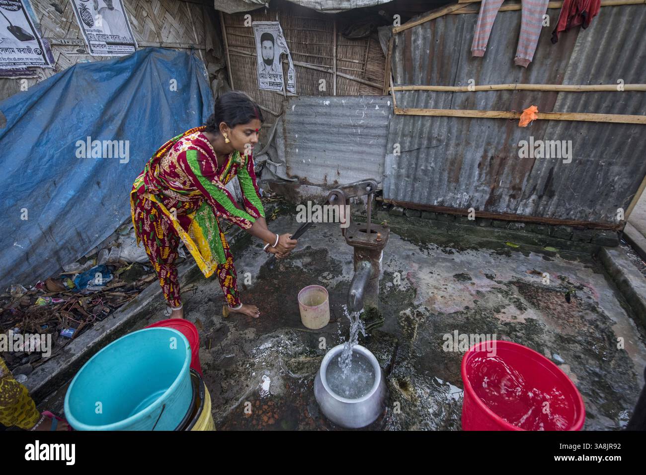 19 mars 2017 - Khulna, Khulna, Bangladesh - Bangladesh, Khulna, colonie de balayeuses Sonadanga. La plupart de ces personnes qui vivent dans ce bidonville sont des Dalits hindous, ou la caste intouchable travaillant comme balayeuses et nettoyeuses de toilettes. Il y a environ 5,5 millions de Dalits à travers le pays, ce sont les castes les plus négligées dans la société. Femmes pompant de l'eau au puits. (Crédit image : © Alison Wright via ZUMA Wire) Banque D'Images