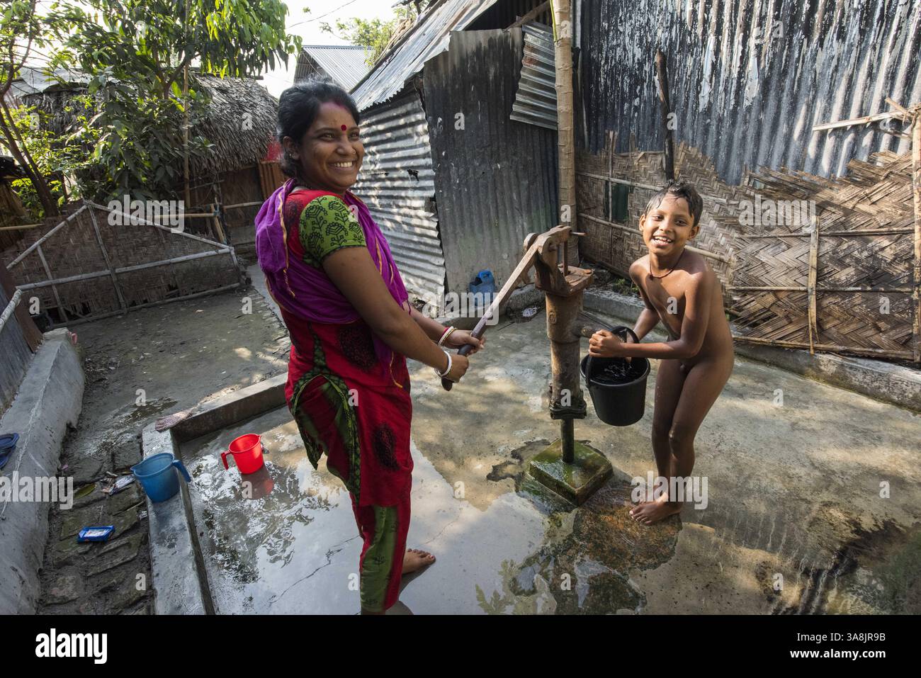 19 mars 2017 - Khulna, Khulna, Bangladesh - Bangladesh, Khulna, colonie de balayeuses Sonadanga. La plupart de ces personnes qui vivent dans ce bidonville sont des Dalits hindous, ou la caste intouchable travaillant comme balayeuses et nettoyeuses de toilettes. Il y a environ 5,5 millions de Dalits à travers le pays, ce sont les castes les plus négligées dans la société. Femmes pompant de l'eau au puits. (Crédit image : © Alison Wright via ZUMA Wire) Banque D'Images