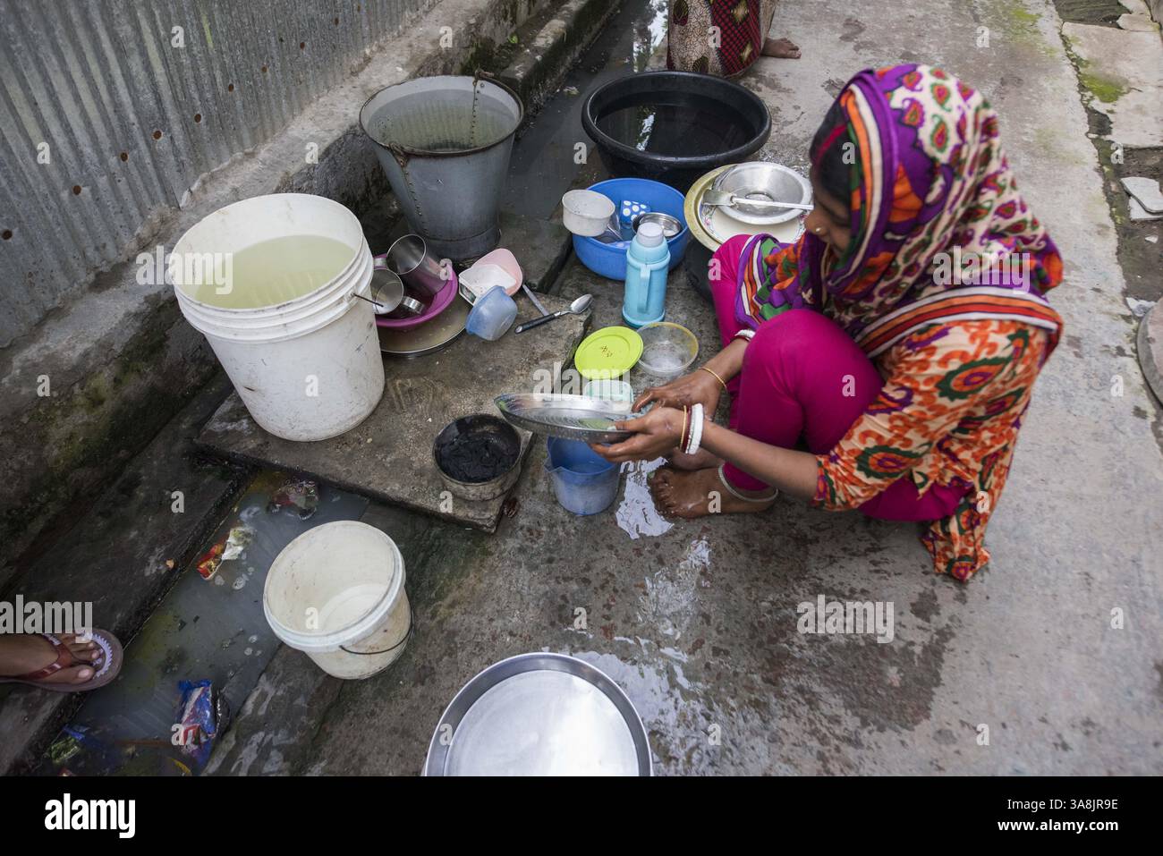 19 mars 2017 - Khulna, Khulna, Bangladesh - Bangladesh, Khulna, colonie de balayeuses Sonadanga. La plupart de ces personnes qui vivent dans ce bidonville sont des Dalits hindous, ou la caste intouchable travaillant comme balayeuses et nettoyeuses de toilettes. Il y a environ 5,5 millions de Dalits à travers le pays, ce sont les castes les plus négligées dans la société. Femmes pompant de l'eau au puits. (Crédit image : © Alison Wright via ZUMA Wire) Banque D'Images