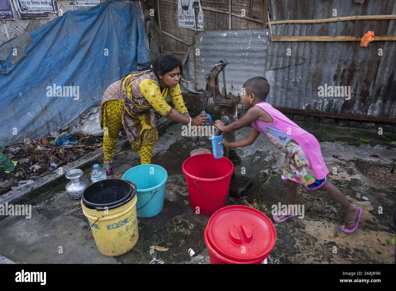 19 mars 2017 - Khulna, Khulna, Bangladesh - Bangladesh, Khulna, colonie de balayeuses Sonadanga. La plupart de ces personnes qui vivent dans ce bidonville sont des Dalits hindous, ou la caste intouchable travaillant comme balayeuses et nettoyeuses de toilettes. Il y a environ 5,5 millions de Dalits à travers le pays, ce sont les castes les plus négligées dans la société. Femmes pompant de l'eau au puits. (Crédit image : © Alison Wright via ZUMA Wire) Banque D'Images