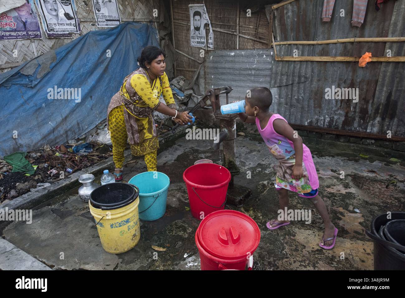 19 mars 2017 - Khulna, Khulna, Bangladesh - Bangladesh, Khulna, colonie de balayeuses Sonadanga. La plupart de ces personnes qui vivent dans ce bidonville sont des Dalits hindous, ou la caste intouchable travaillant comme balayeuses et nettoyeuses de toilettes. Il y a environ 5,5 millions de Dalits à travers le pays, ce sont les castes les plus négligées dans la société. Femmes pompant de l'eau au puits. (Crédit image : © Alison Wright via ZUMA Wire) Banque D'Images