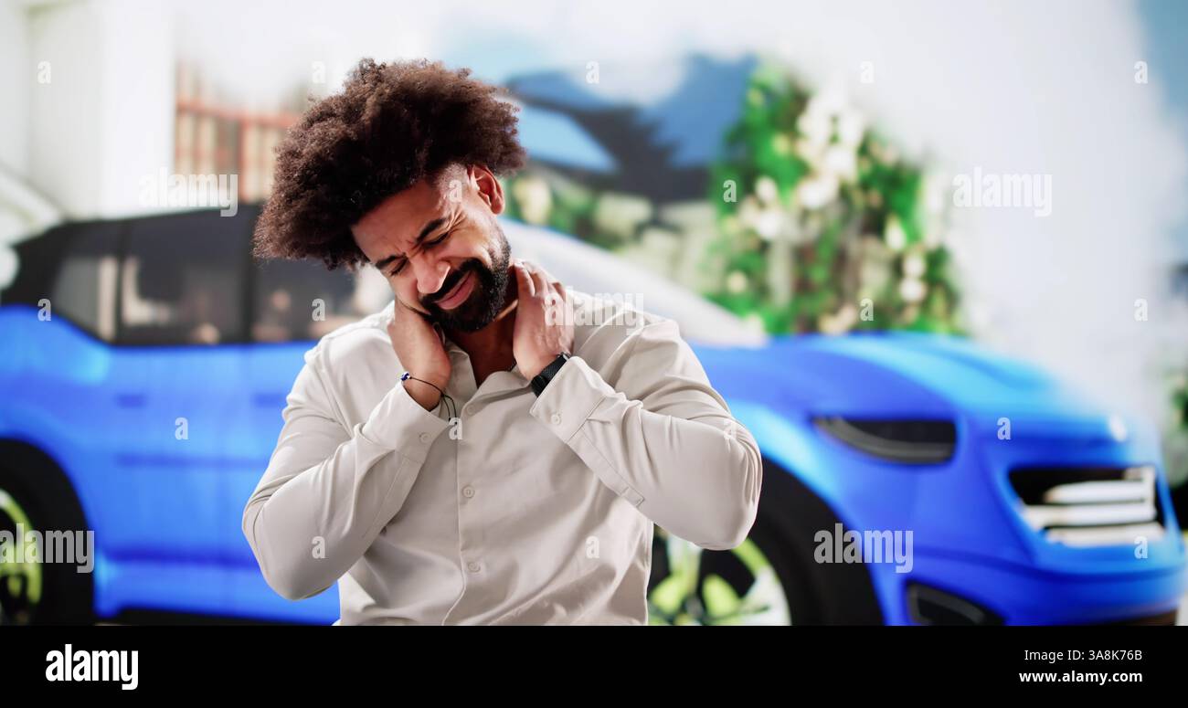 Jeune afro-américain douloureux à proximité d'un accident de voiture fumant. Banque D'Images