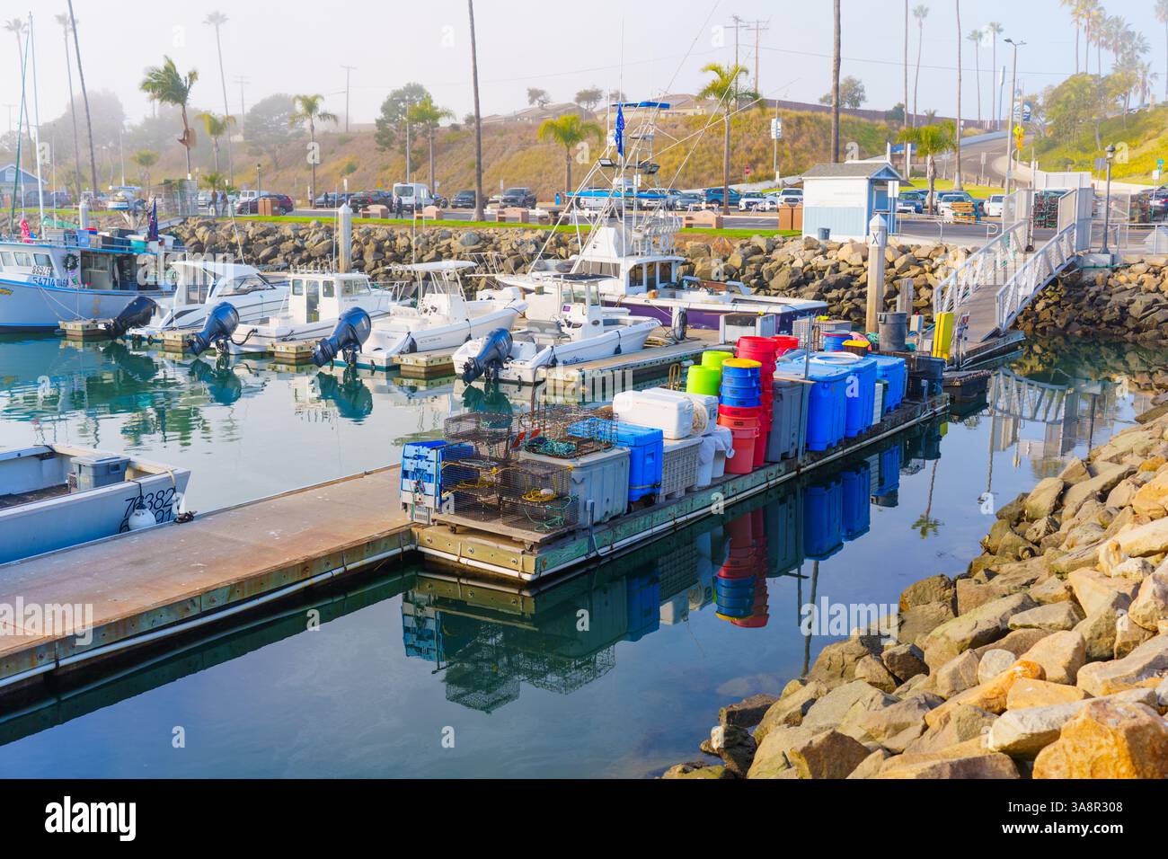 Oceanside, Californie - 3 janvier 2025 : port tranquille à Oceanside, Californie, présentant des bateaux de pêche et des poubelles vibrantes sous une matinée douce Banque D'Images