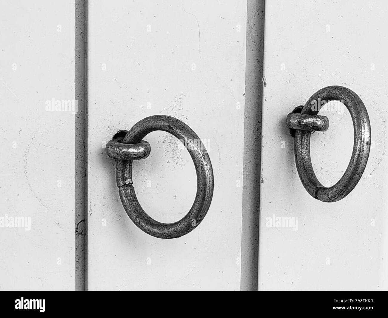 Anneaux de symétrie argentés , sur cadre de porte blanc. Banque D'Images
