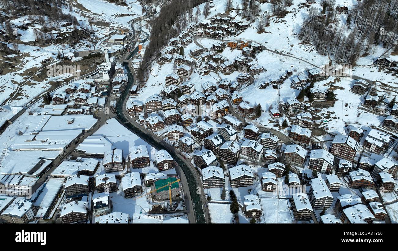 Vue aérienne du village enneigé avec arrière-plan du sommet de montagne emblématique Matterhorn, certains hôtels sont fermés en hiver. Banque D'Images