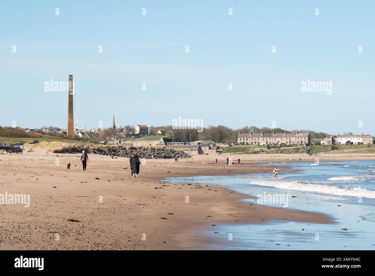 Les gens marchent sur la plage de Spittal avec Berwick upon Tweed en arrière-plan, Northumberland, Angleterre, Royaume-Uni Banque D'Images