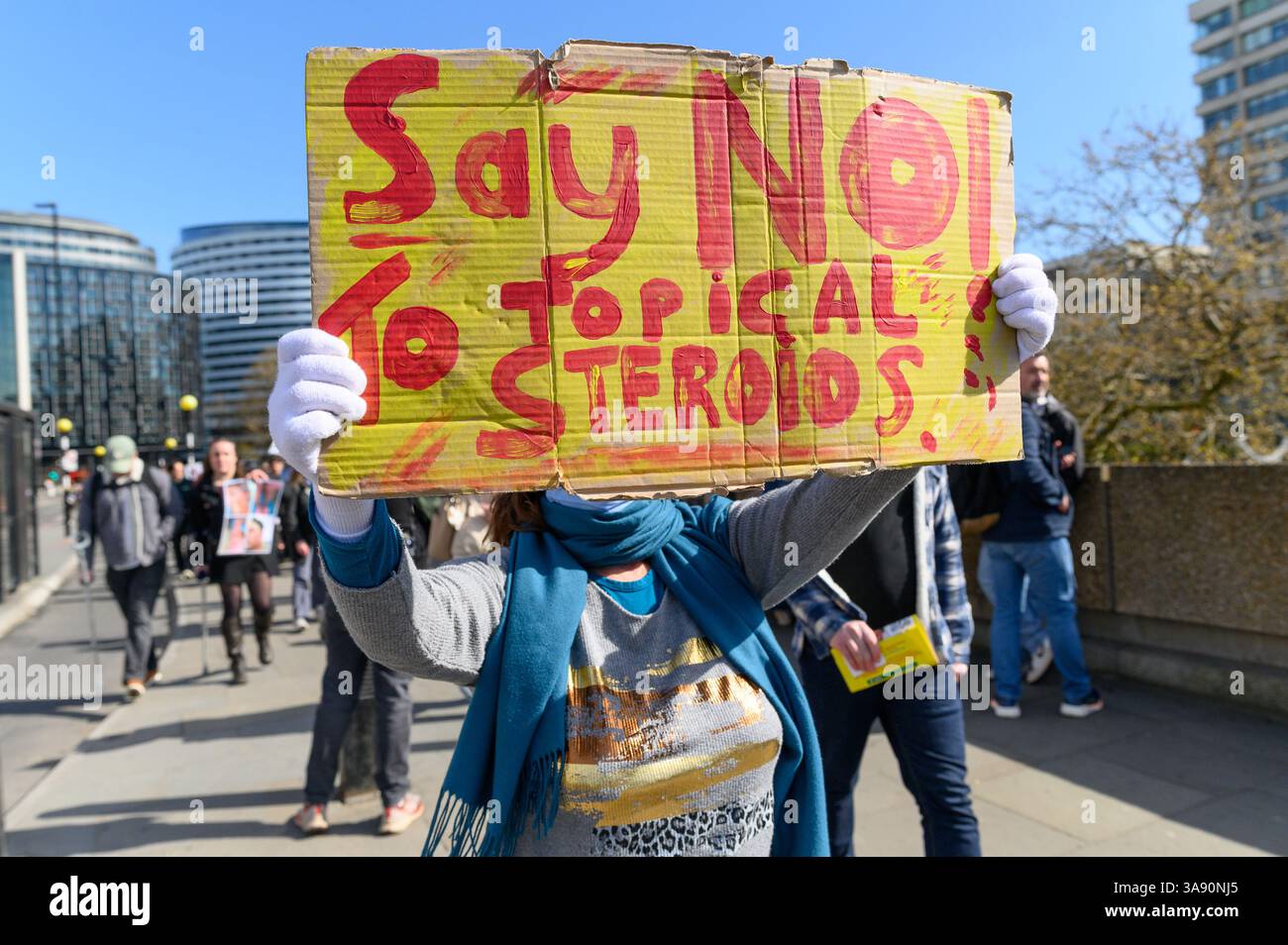 Londres, Royaume-Uni, 29 mars 2025. Les personnes qui souffrent ou ont souffert de sevrage topique des stéroïdes, également connu sous le nom de syndrome de la peau rouge, se sont rassemblées devant l’hôpital St Thomas à Londres pour protester contre les médecins et les dermatologues qui ont prescrit trop de stéroïdes pour traiter l’eczéma, causant aux patients de souffrir de TSW. Crédit : Andrea Domeniconi/Alamy Live News Banque D'Images