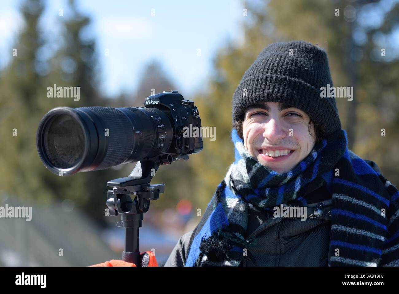 Jeune photographe avec appareil photo Nikon et téléobjectif Banque D'Images