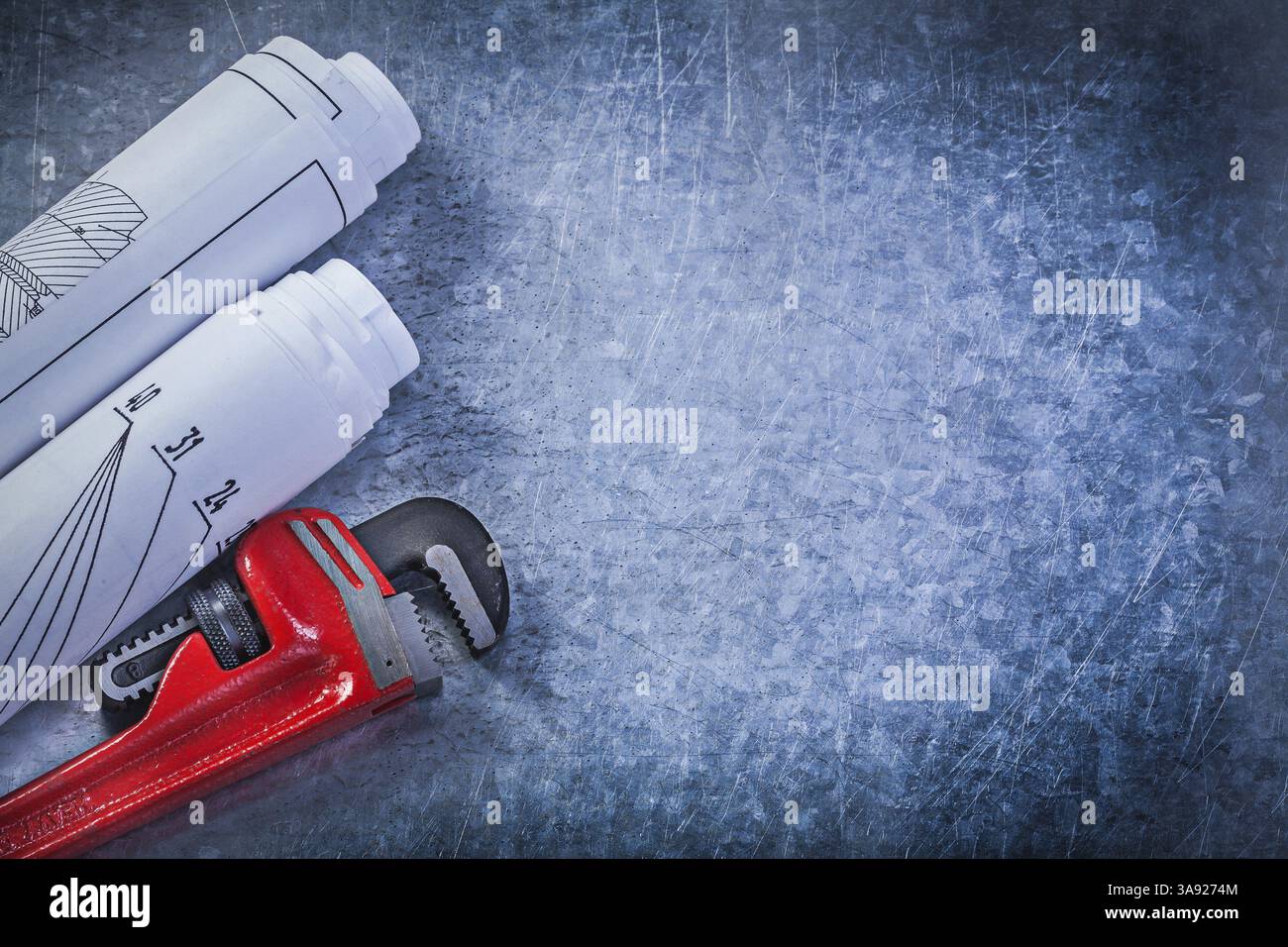 Dessins de construction roulés à clé réglable singe sur fond métallique rayé concept de plomberie Banque D'Images