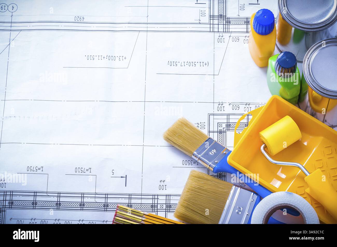Le mètre en bois de ruban ménager et le pinceau bidon de bouteilles rouleau de plateau sur le concept de maintenance de dessin de construction Banque D'Images
